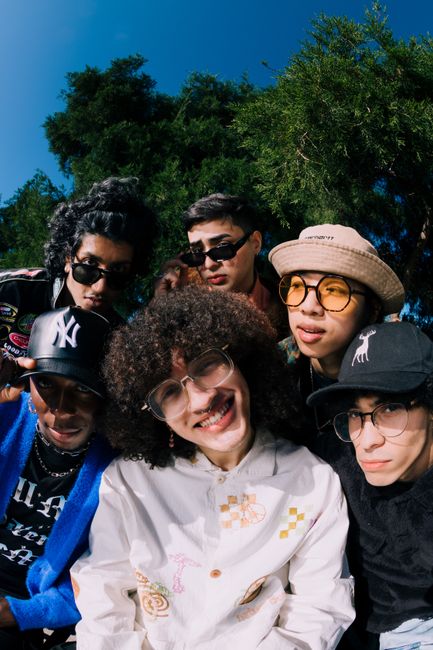 Group of stylish teenagers having fun outdoors, wearing trendy outfits and eyewear.