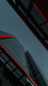 Dramatic view of illuminated skyscrapers with red lights against a night sky.