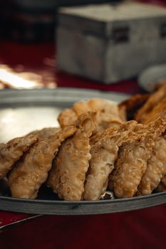 Close-up of crispy fried snack on a metal plate, perfect for culinary content.