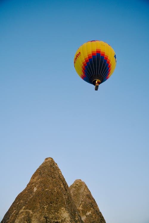 Hot Air Balloon Floating Over Mountain Peaks