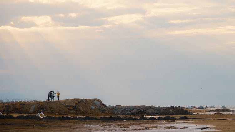 People Standing On A Seashore 