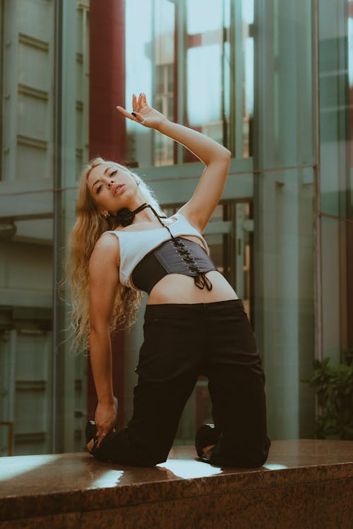 Woman in Crop Top and Corset Posing on a Bench