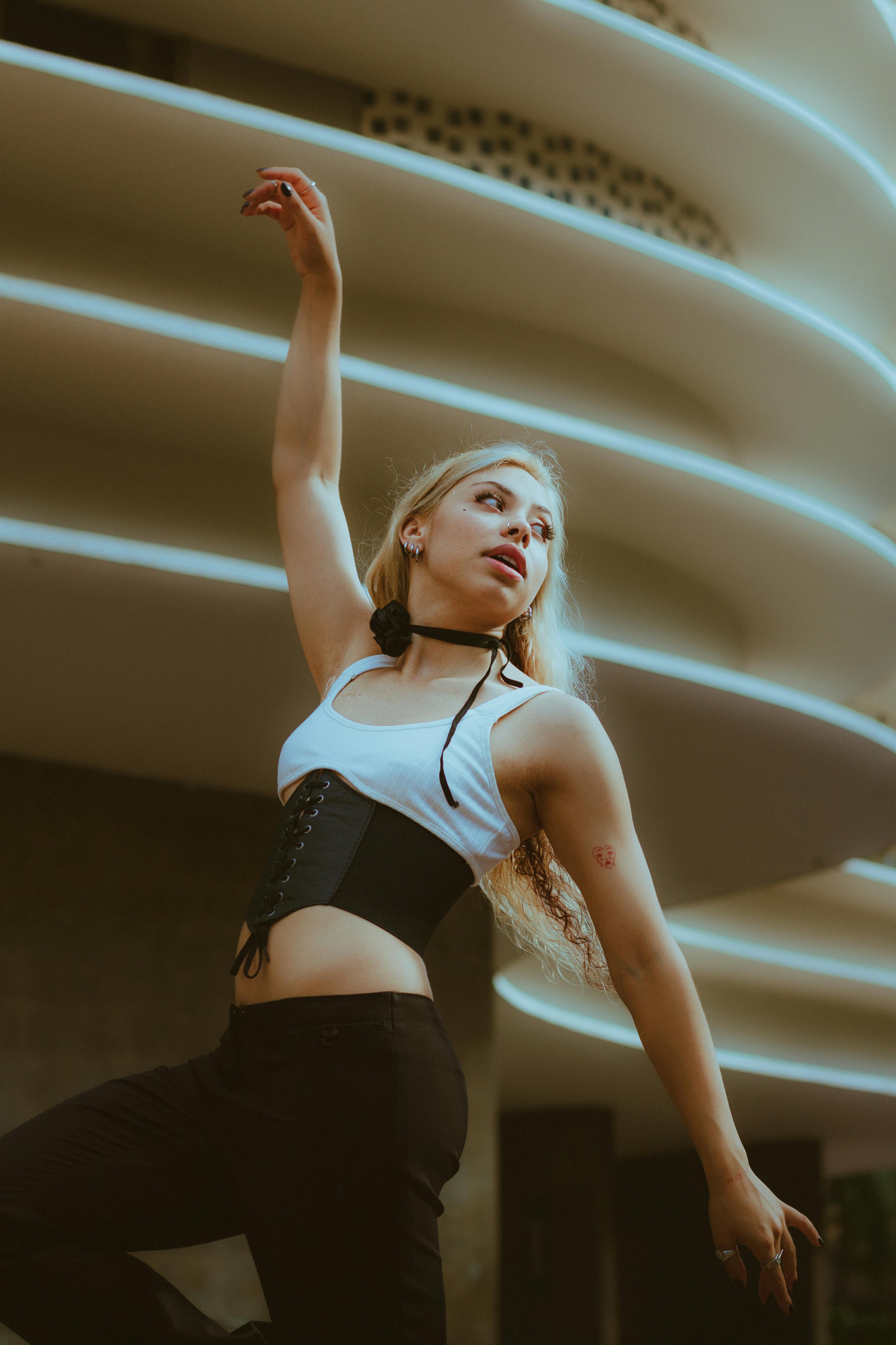 young woman posing in front of a modern building