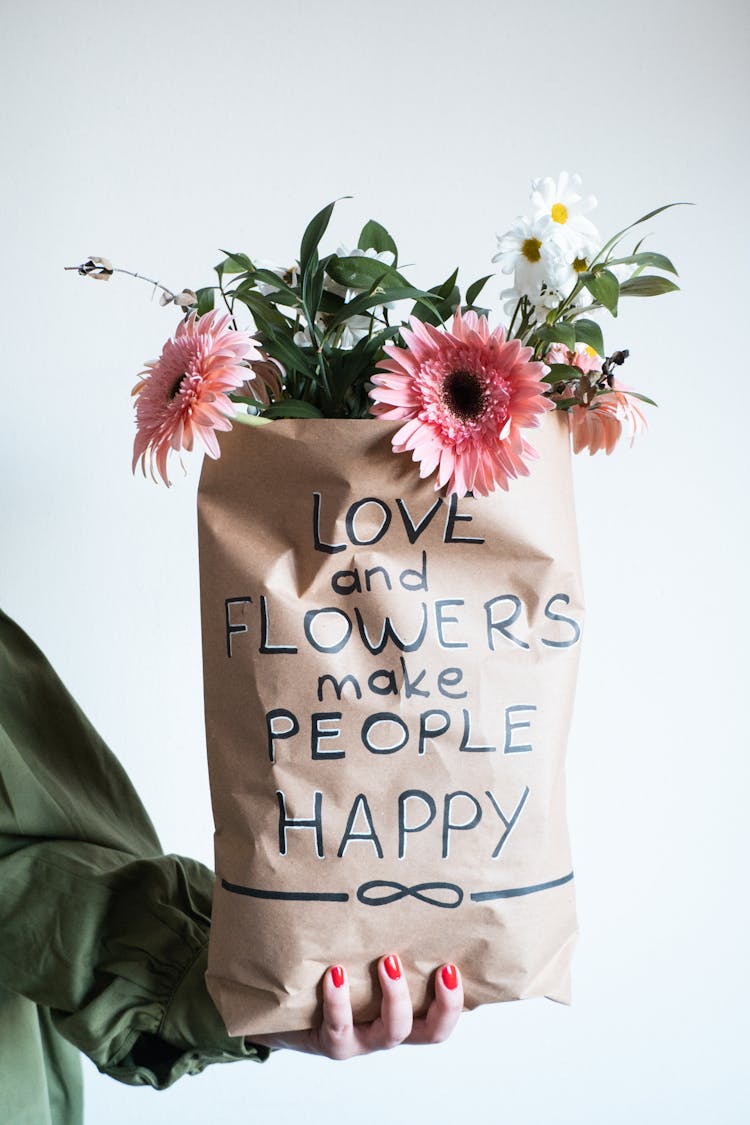 Woman Holding Flowers In A Paper Bag 