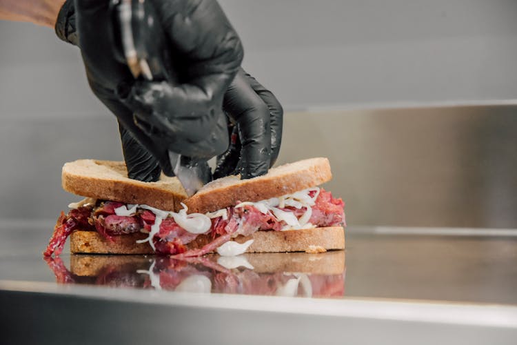 Hands In Gloves Cutting Sandwich