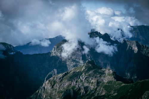Free A majestic mountain range shrouded in clouds, offering a dramatic view of rugged peaks. Stock Photo
