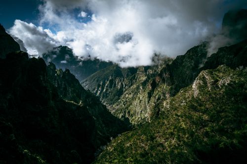 Free A breathtaking view of a mountain valley with dramatic cloud formations overhead. Stock Photo