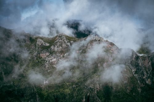 Free Captivating view of mountains with clouds and mist, depicting natural erosion and rugged terrain. Stock Photo