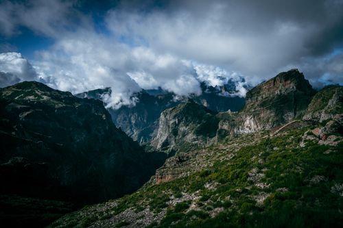 Free A breathtaking mountain landscape with rugged cliffs and dramatic clouds, showcasing natural beauty. Stock Photo