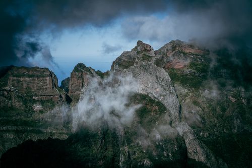 Free A stunning aerial photograph capturing eroded mountain peaks shrouded in clouds and mist, creating a dramatic nature scene. Stock Photo
