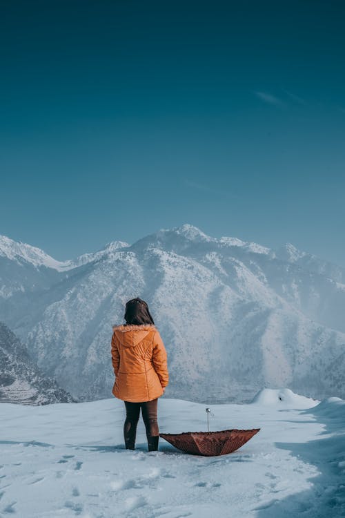 Woman in Jacket Standing in Mountains