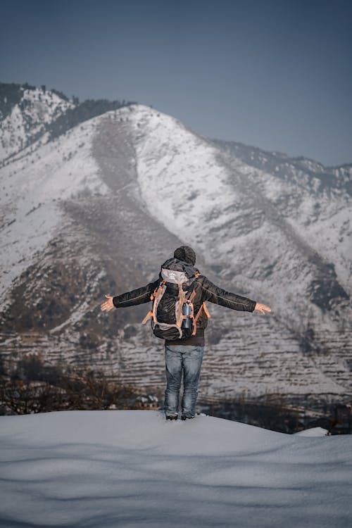 Free Man with Backpack Hiking in Mountains in Winter Stock Photo