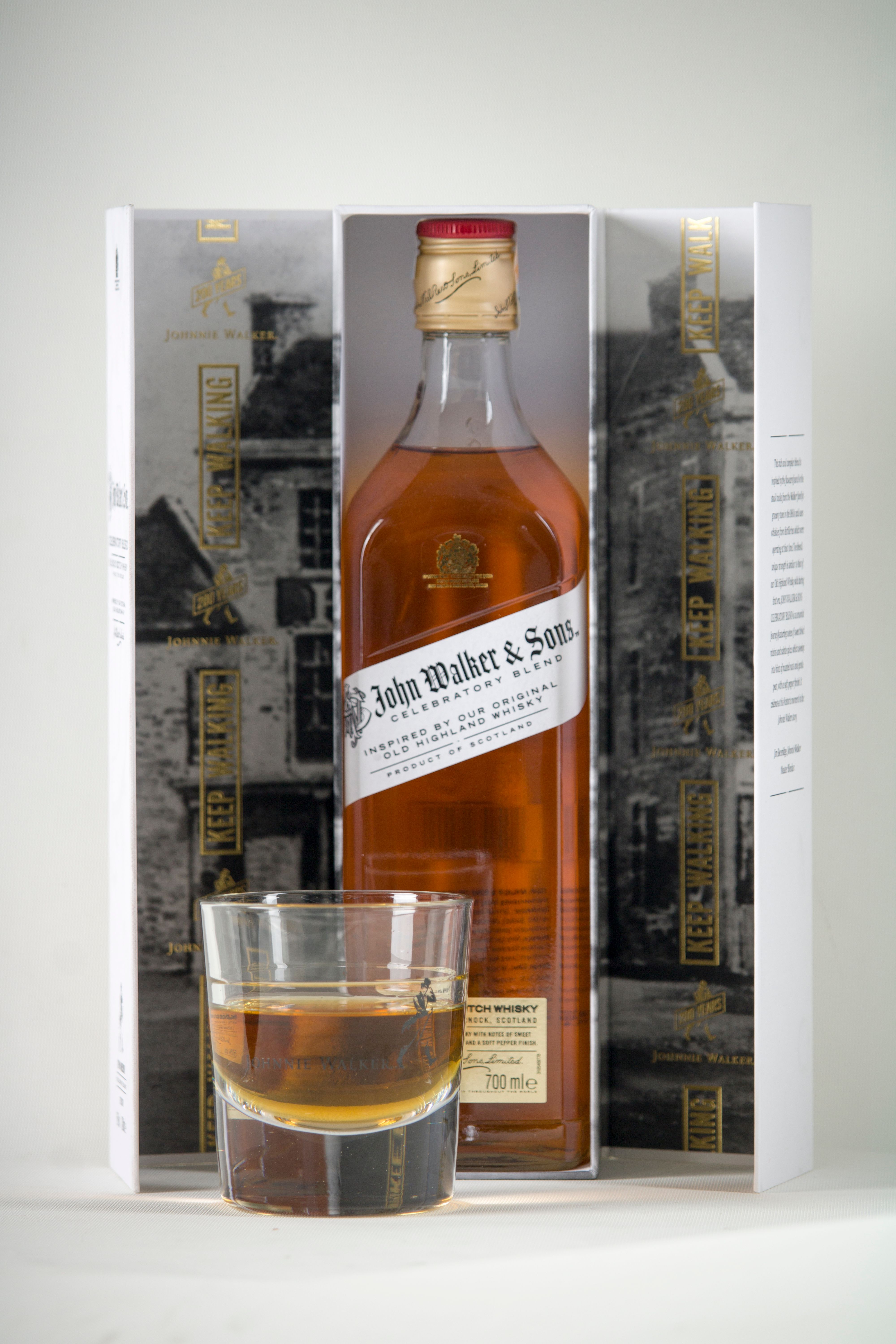 A bottle of premium whiskey alongside a glass, elegantly set against a white background.