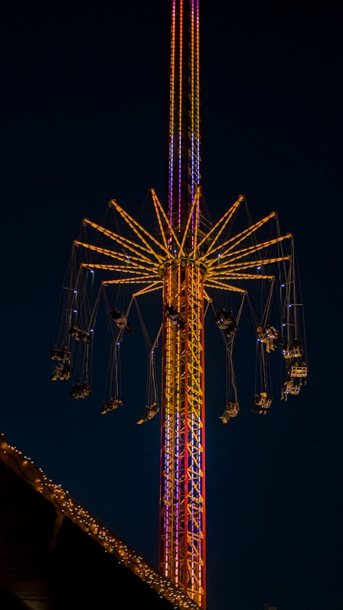 Illuminated Drop Tower in Amusement Park at Night