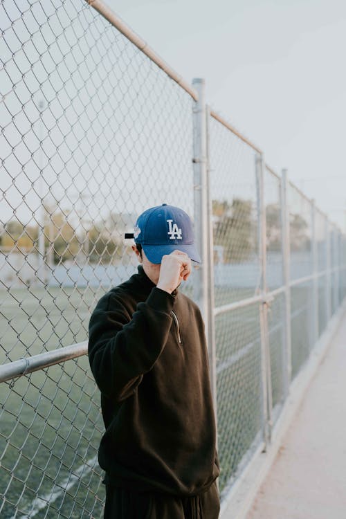 Man Holding Blue Baseball Cap