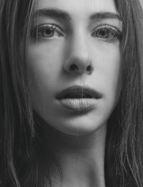 Free Close-up black and white portrait of a young woman with long hair, exuding a moody vibe. Stock Photo