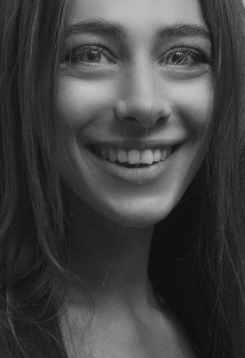 Free A black and white close-up portrait of a smiling woman with a natural expression. Stock Photo