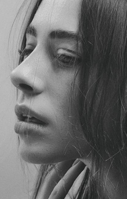 Close-up black and white portrait of a woman expressing deep emotion.