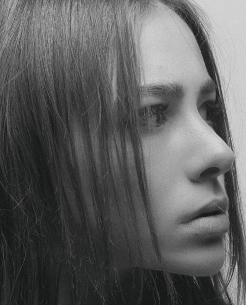 Free Close-up black and white portrait of a young woman looking pensive and thoughtful. Stock Photo