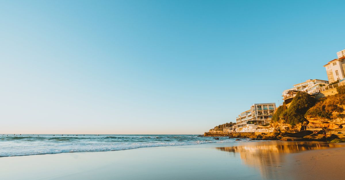 Stunning sunset at Bondi Beach, showcasing ocean waves and coastal homes.