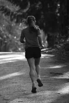 Silhouette of a woman jogging outdoors, embracing a healthy lifestyle.