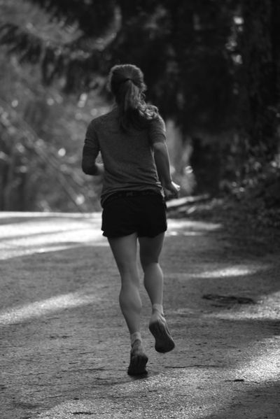 Black and White Picture of a Woman Running along an Alley Lined with ...