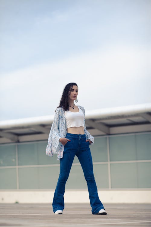 Woman in Tank Top and Denim Pants Posing