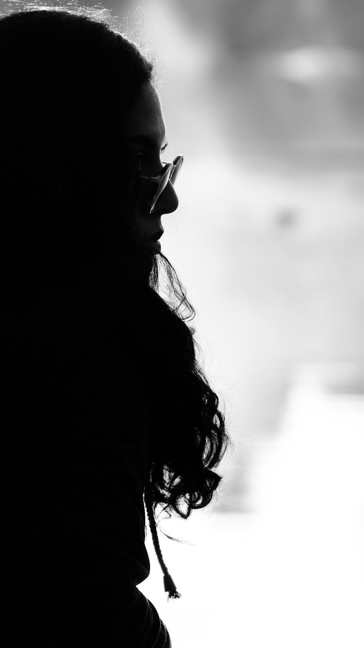 Silhouette Of Woman In Glasses Posing Outdoors