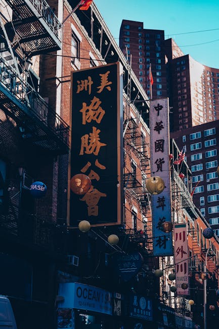 Photo by EME Photography Vibrant Chinatown street with colorful signs and urban architecture during the day.