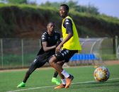 Two male soccer players training on an outdoor field, showcasing agility and movement.
