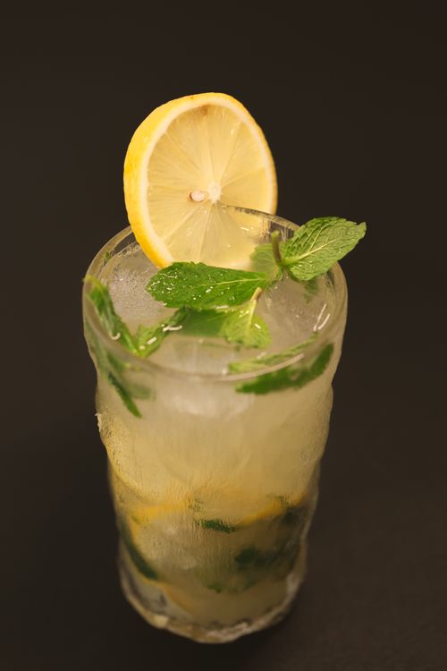 Free Close-up shot of an iced lemon mint drink in a glass on a dark background. Stock Photo