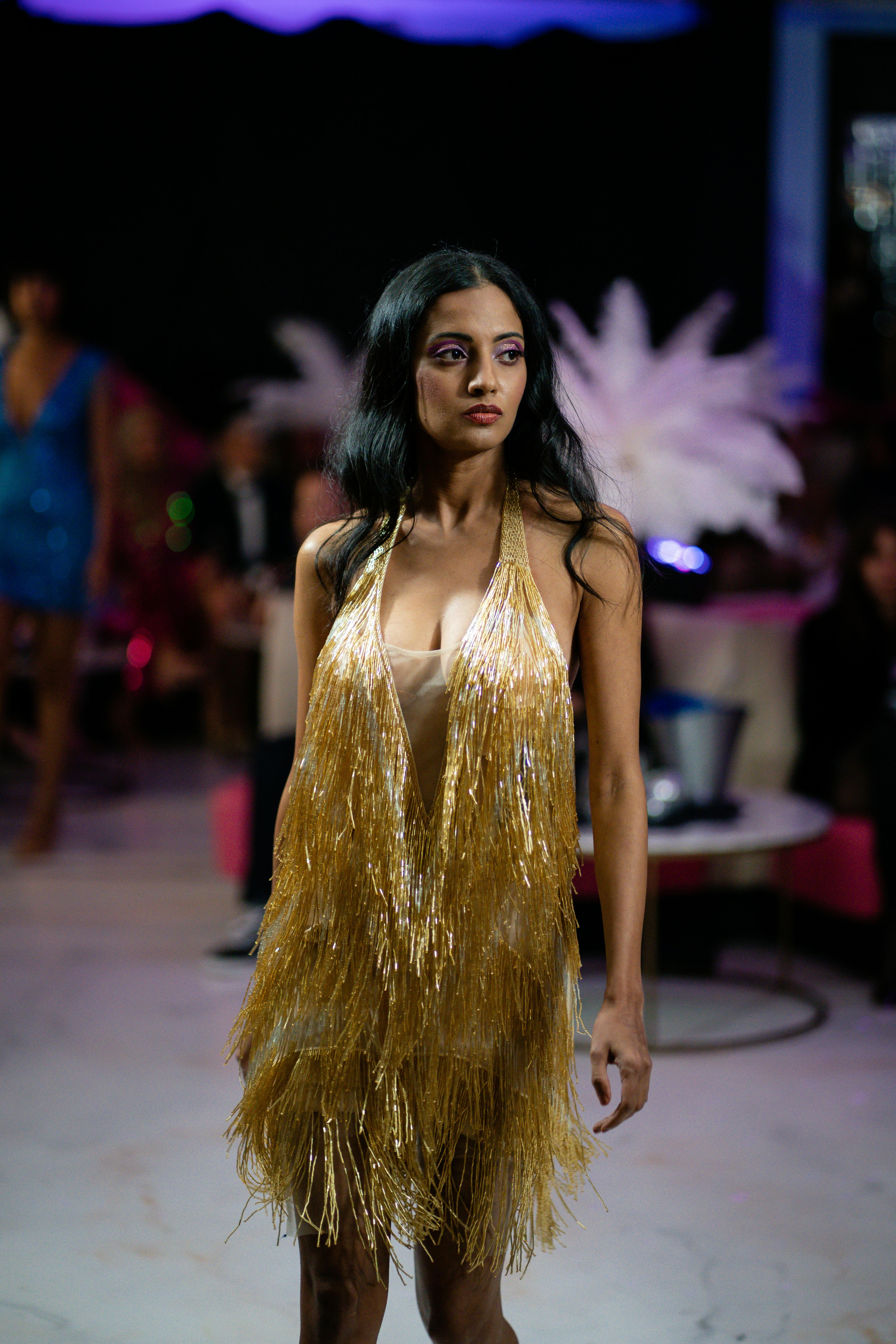 model in a golden dress on a fashion show