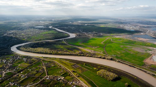 River Flowing in Green Plantations Landscape