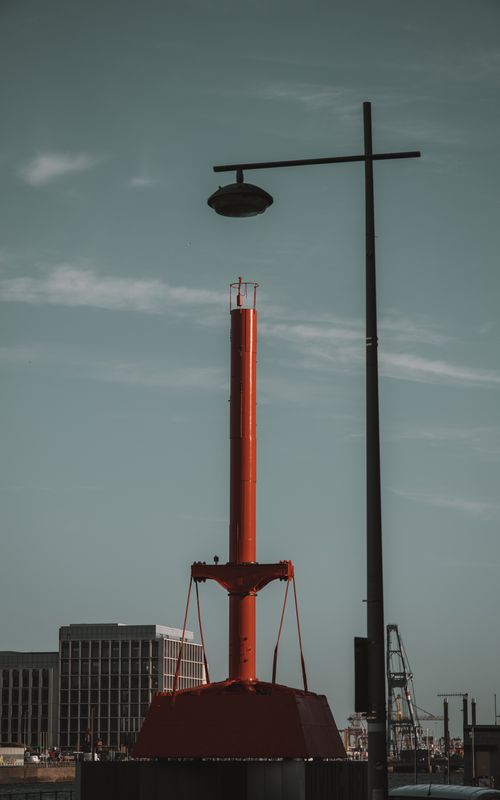 Free A vertical shot of the historic diving bell with a street light against a blue sky in Dublin Port, Ireland. Stock Photo