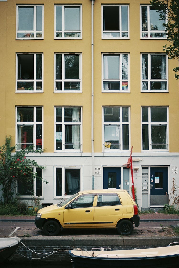 Yellow Car Parked By A Beige Building Near A Canal, Amsterdam, Netherlands