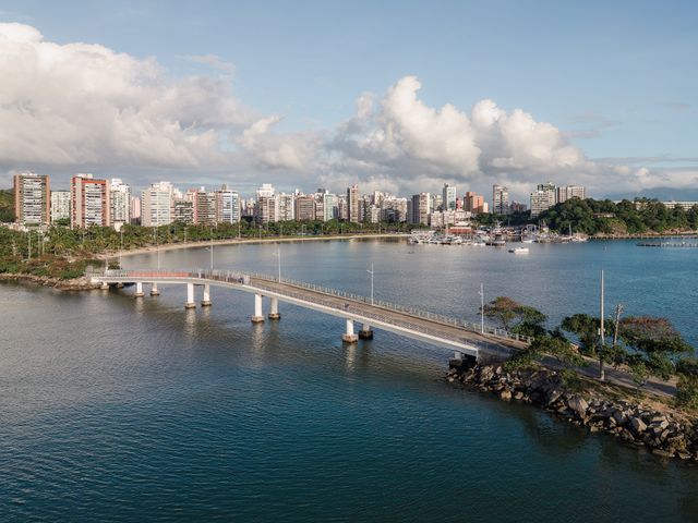 Stunning aerial view of Vitória, ES, Brazil, showcasing the cityscape and bridge over a tranquil body of water.
