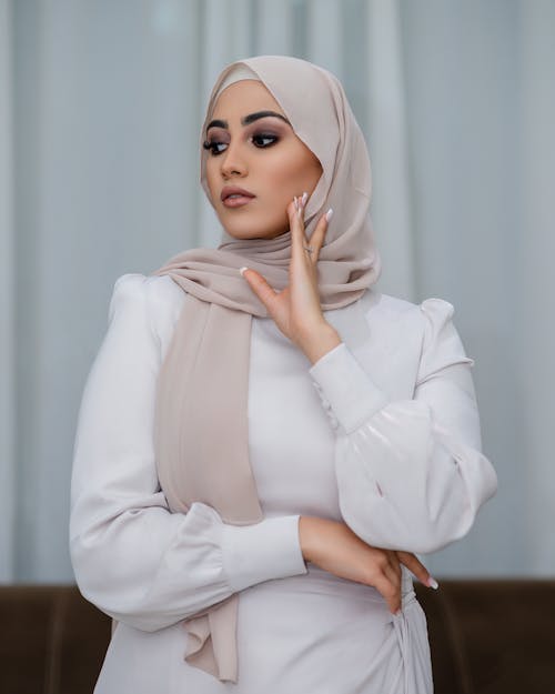 Woman Posing in White Dress and Beige Headscarf
