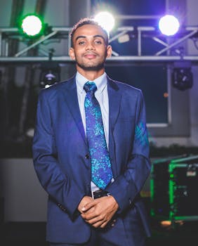A well-dressed man in a blue suit poses confidently at a festive gathering in Managua, Nicaragua.