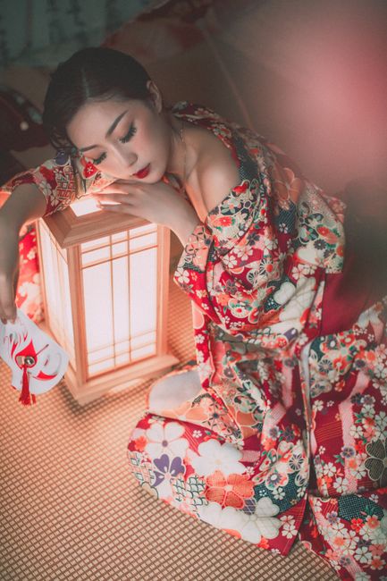 Artistic portrait of a woman in a colorful kimono, captured in soft lighting with a traditional lant