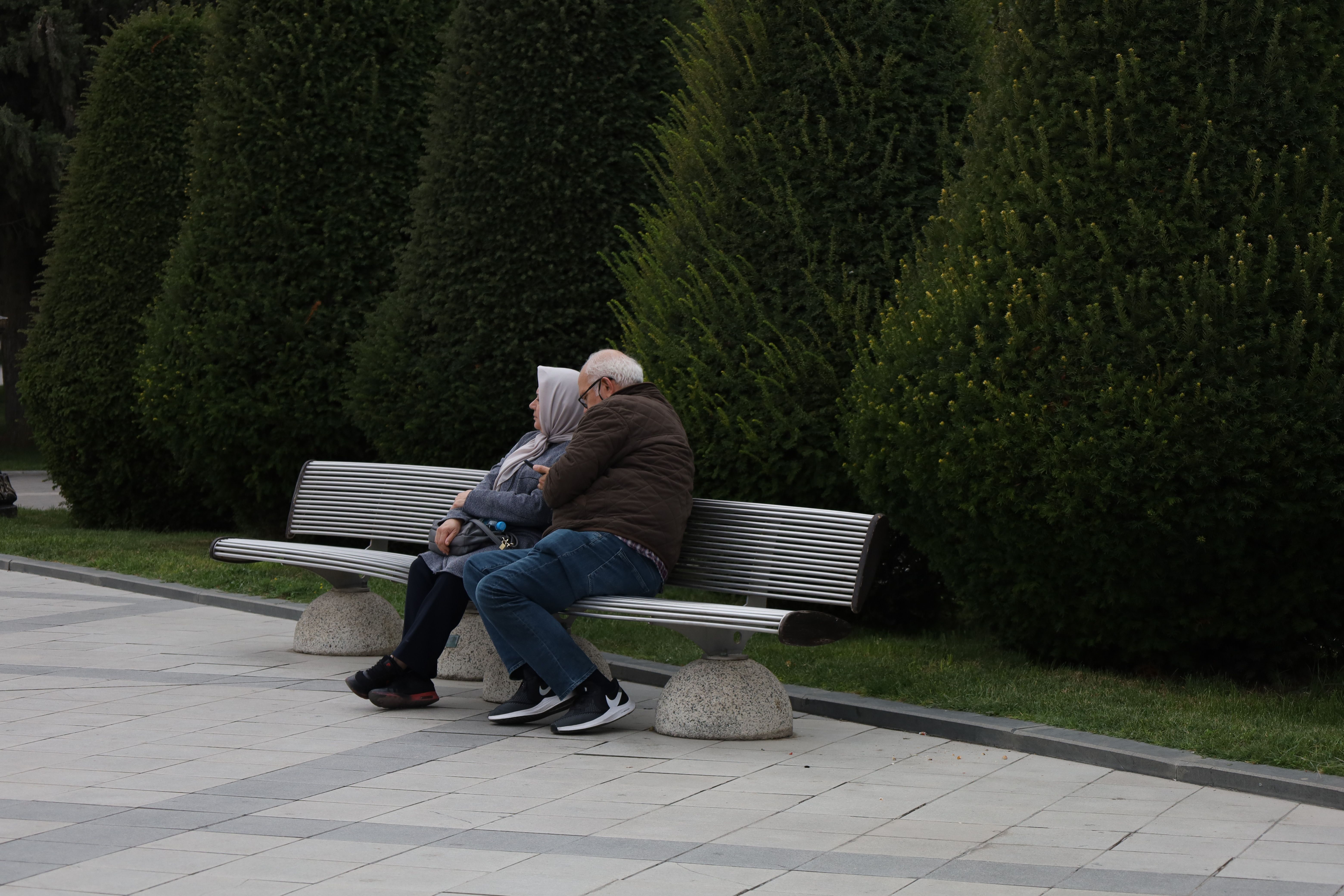 Two Old Men Sitting on Bench in Park in Autumn