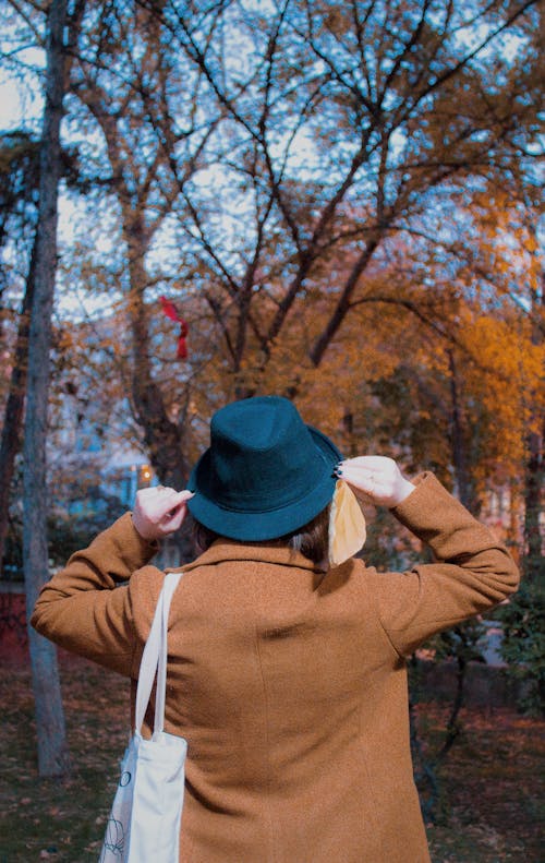 A Person in Brown Coat and Blue Fedora Hat