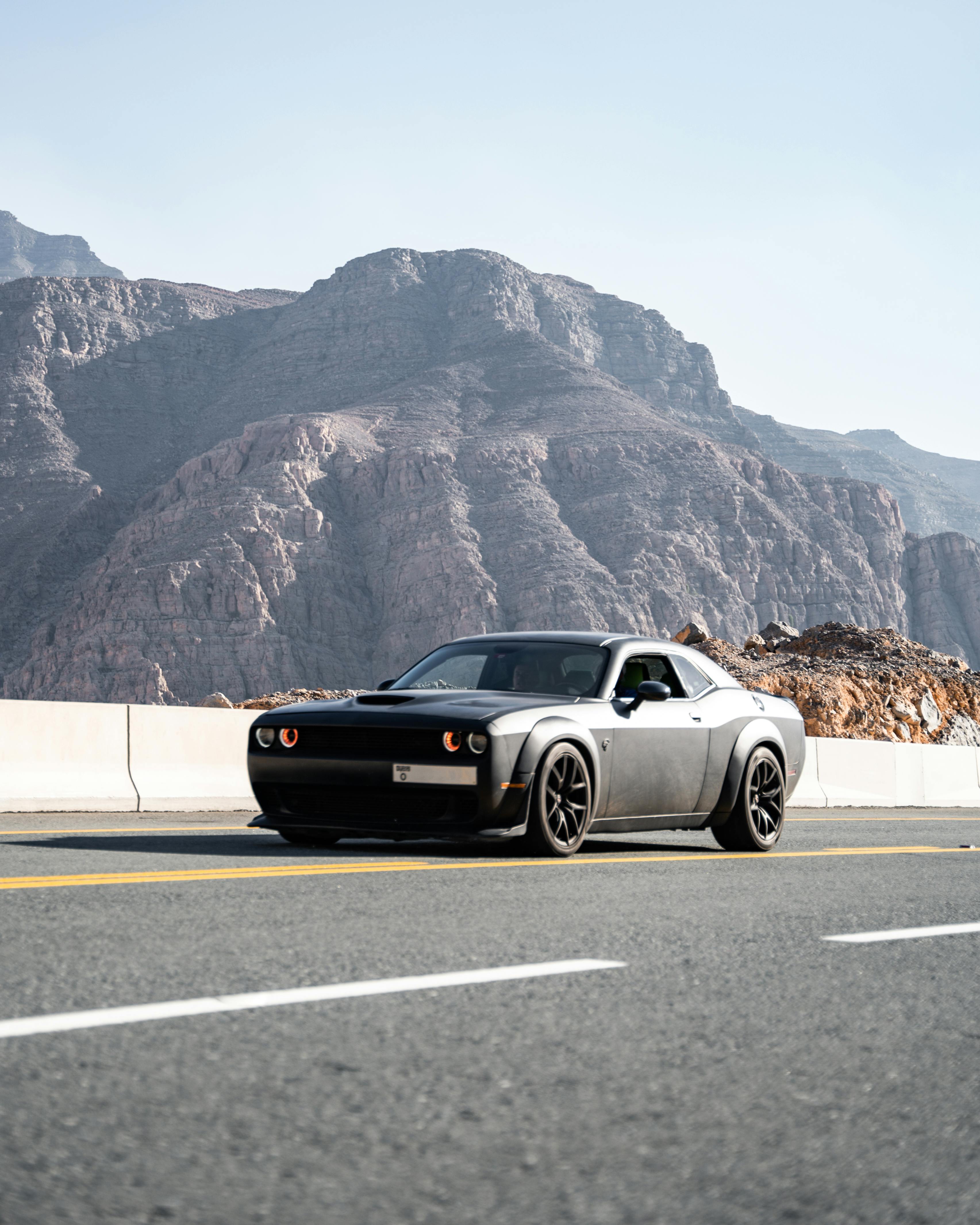 free photo of dodge challenger on a road in mountains