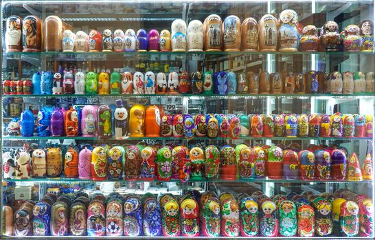 Colorful array of traditional Russian matryoshka dolls showcased in a souvenir shop window.