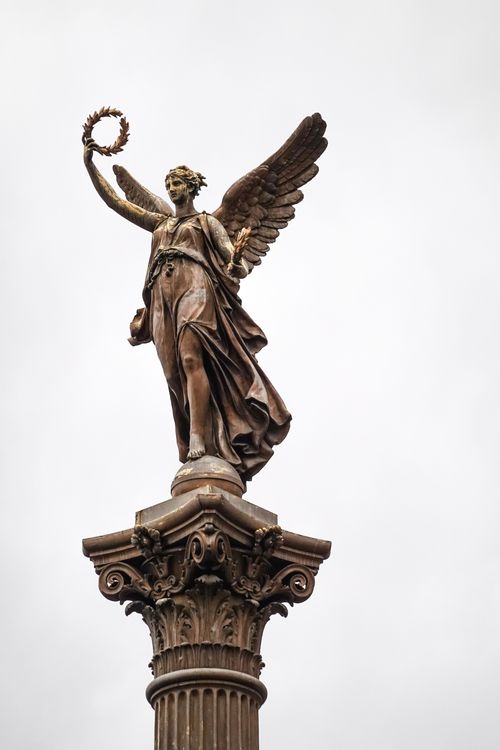 Free Majestic statue of an angel holding a wreath atop a pillar in Rudolfinum, Prague. Stock Photo