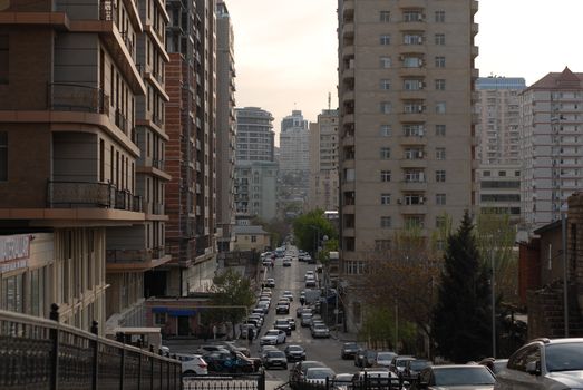 A bustling city street lined with high-rise buildings during sunset, highlighting urban life.