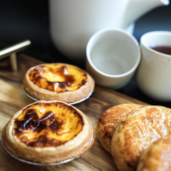 Custard tarts and espresso on a wooden board — photo by Bytes for Food on Pexels
