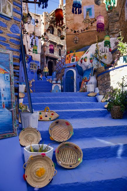 Vibrant Moroccan cityscape with blue stairs, decorative lanterns, and baskets. A perfect blend of culture and color.
