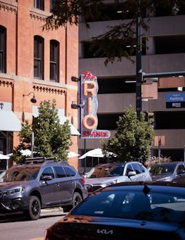 Street view with Rio Grande restaurant sign and parked cars on a sunny day.
