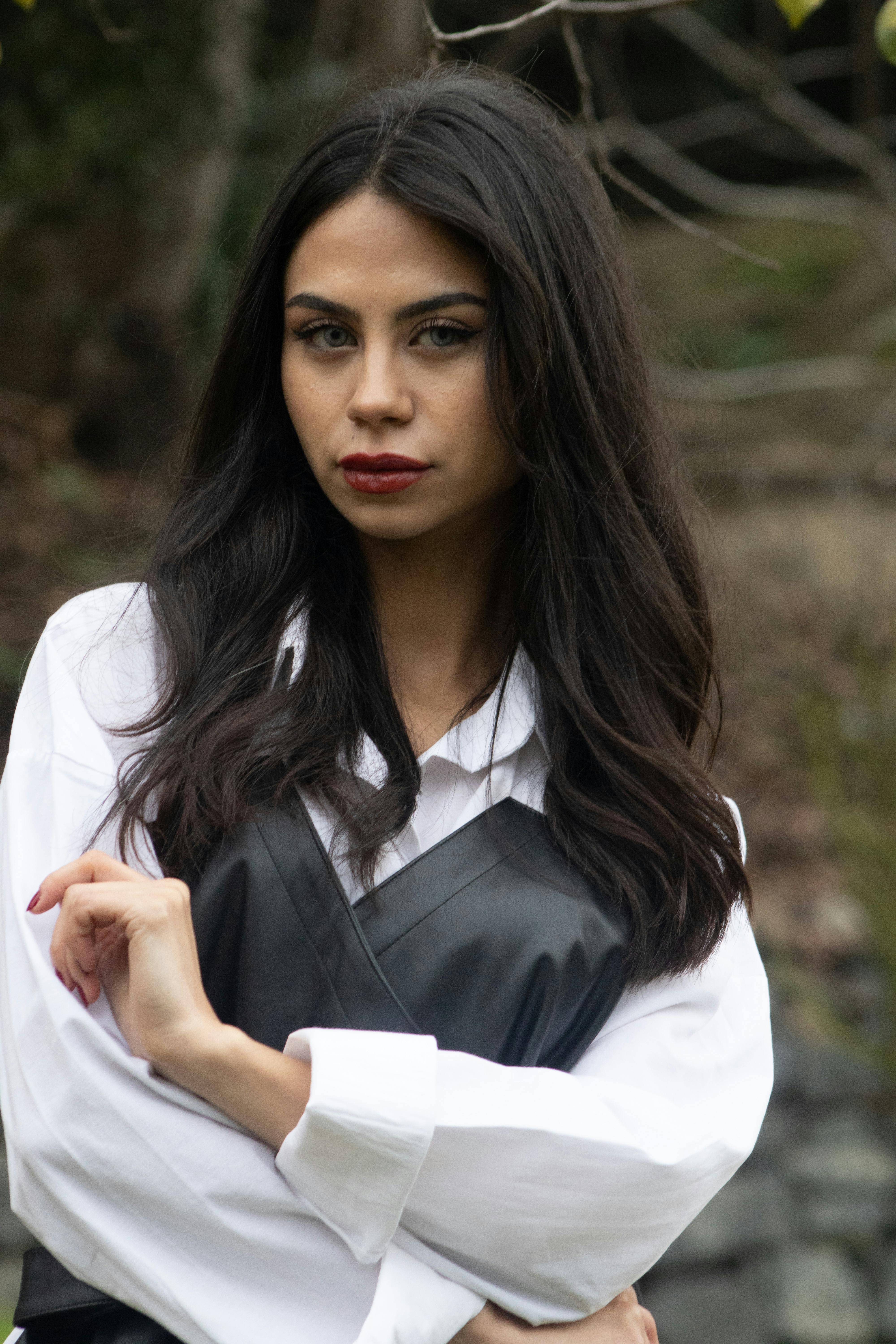 Stylish portrait of a woman posing outdoors, wearing a trendy outfit.