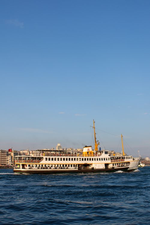 Free A ferry sails on the Bosphorus with Istanbul's iconic skyline as a backdrop under a clear blue sky. Stock Photo